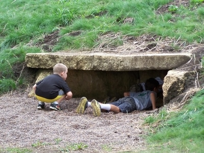 children crawling into a rock tunnel