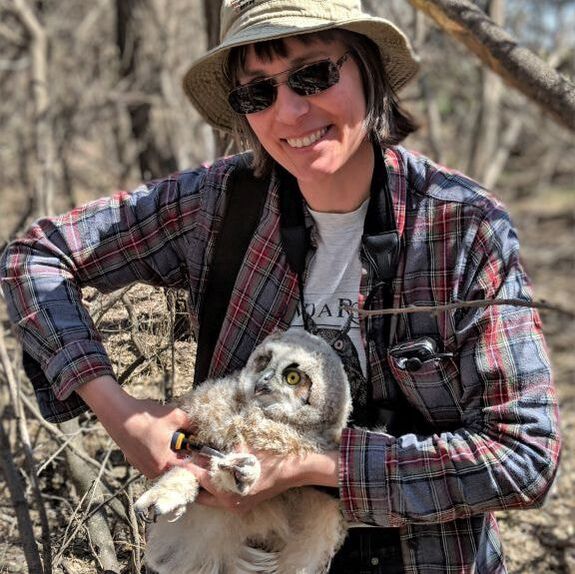 Photo of Karla Bloem wearing a white jacket and holding Alice the great horned owl
